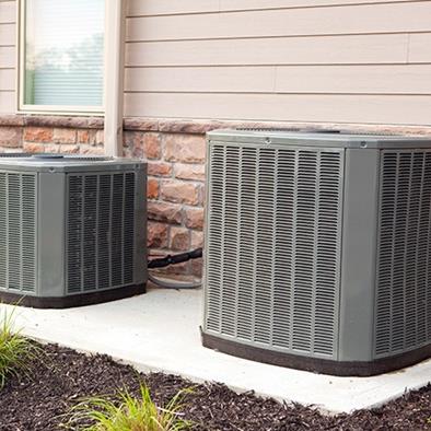 two air conditioner units along a building wall