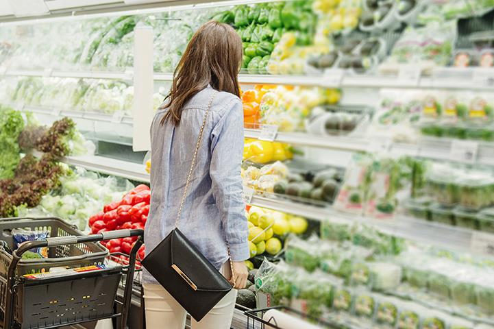 woman browsing refrigerated produce display