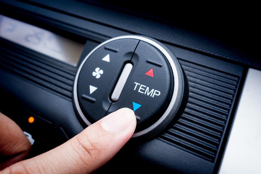 clouseup of persons finger adjusting temperature control on car console 