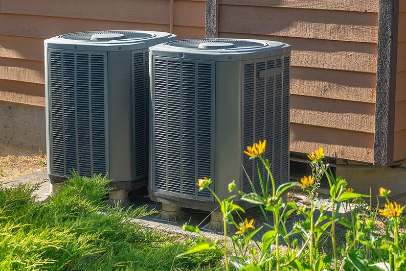 two tall air conditioning units along building exterior wall