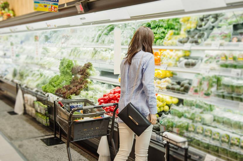 woman browsing refrigerated produce display